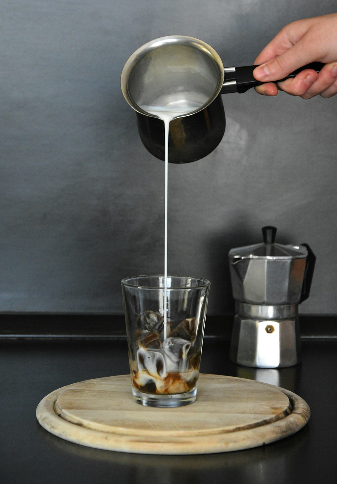 person pouring water on clear drinking glass