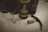 A bottle of artisanal wine with a glass beside it, set on a wooden table with grapevines in the background.