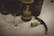 A bottle of artisanal wine with a glass beside it, set on a wooden table with grapevines in the background.