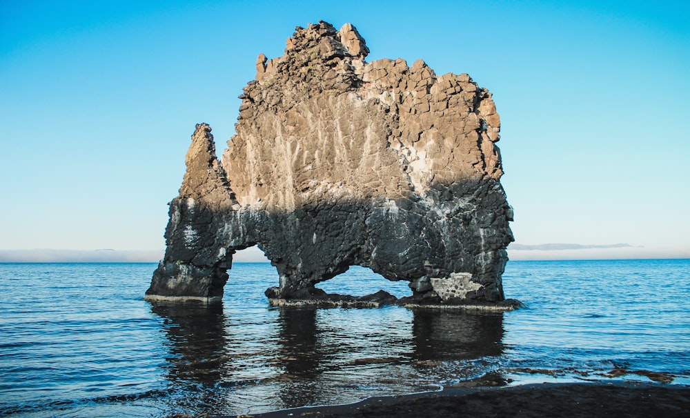 brown rock formation on blue sea under blue sky during daytime