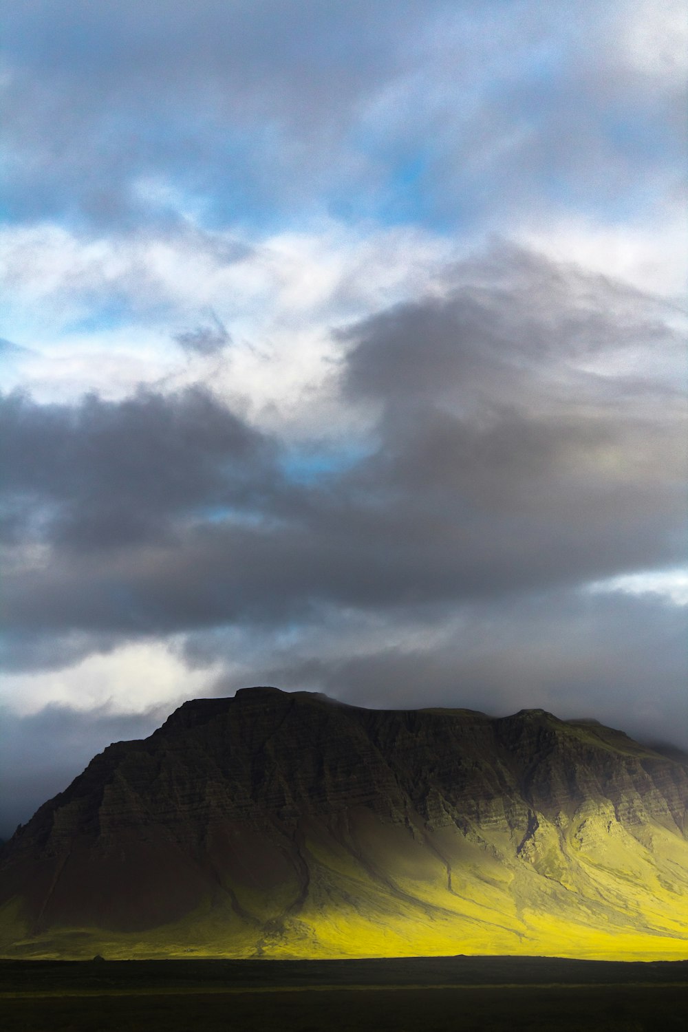 brown and green mountains under white clouds