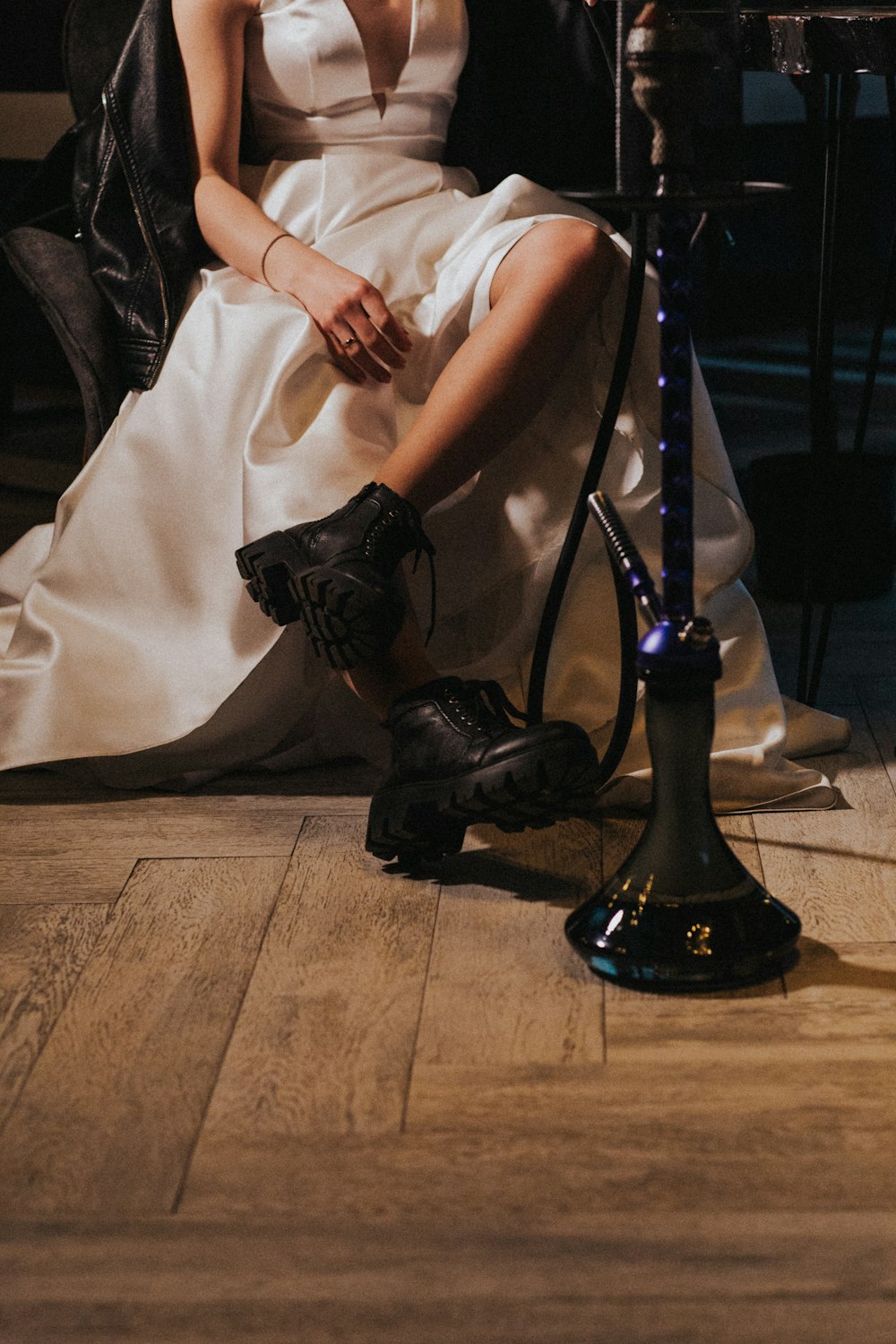 person in black leather boots sitting on chair