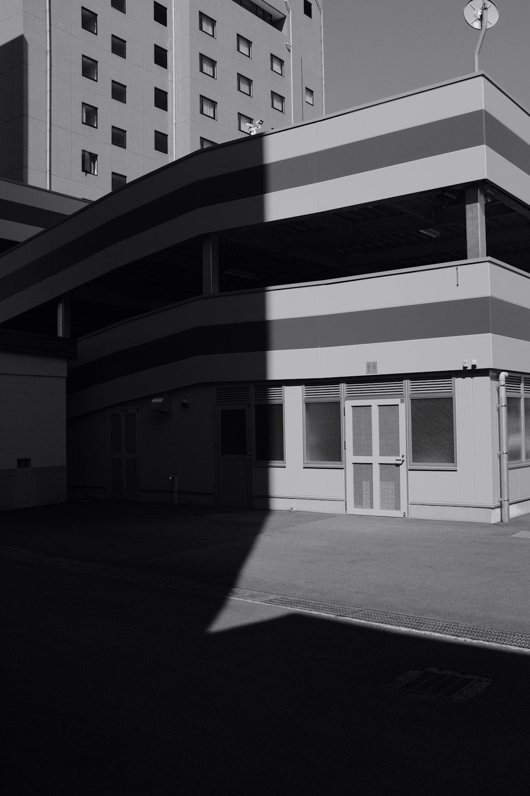 grayscale photo of building with glass windows