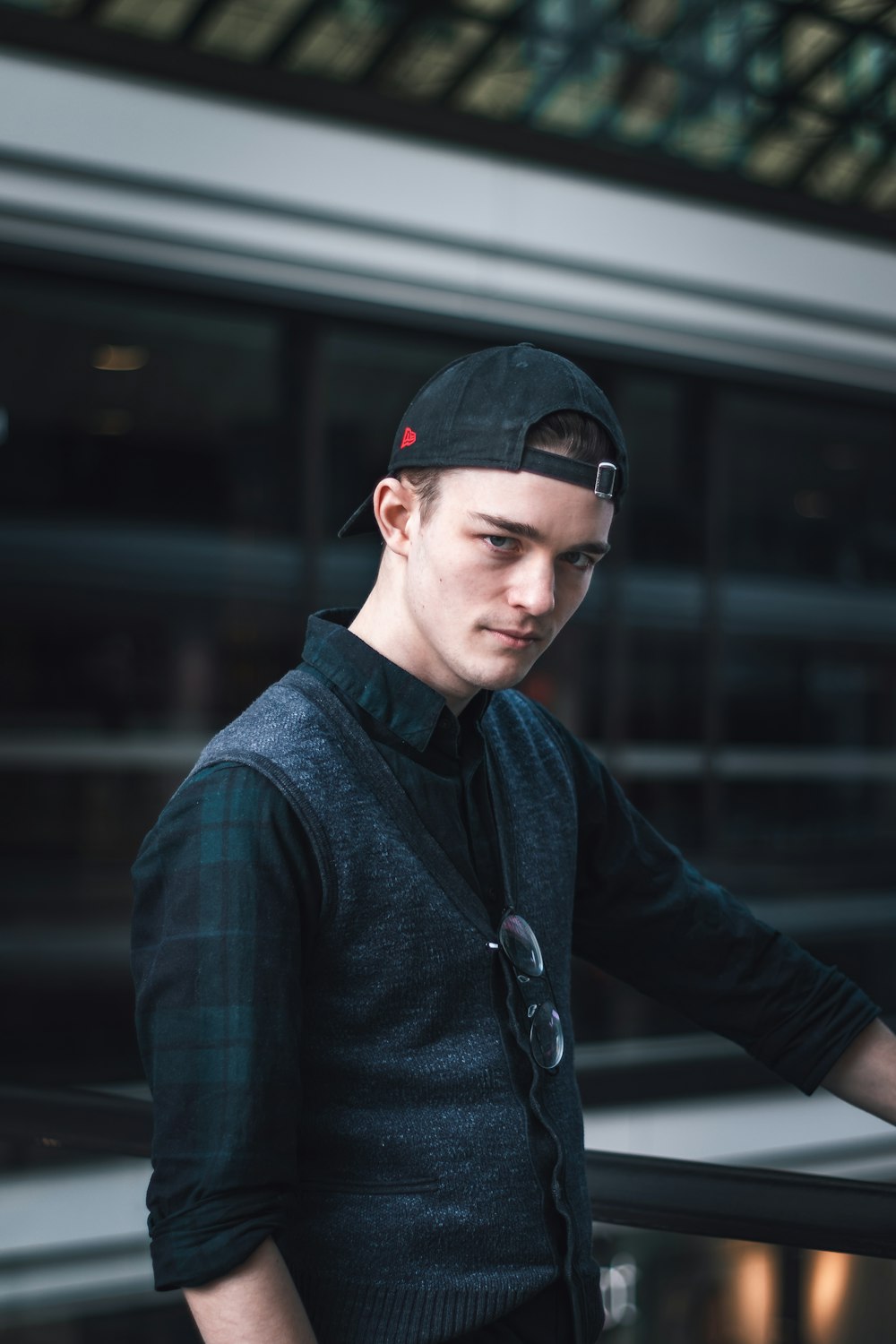 man in blue and black plaid dress shirt wearing black cap