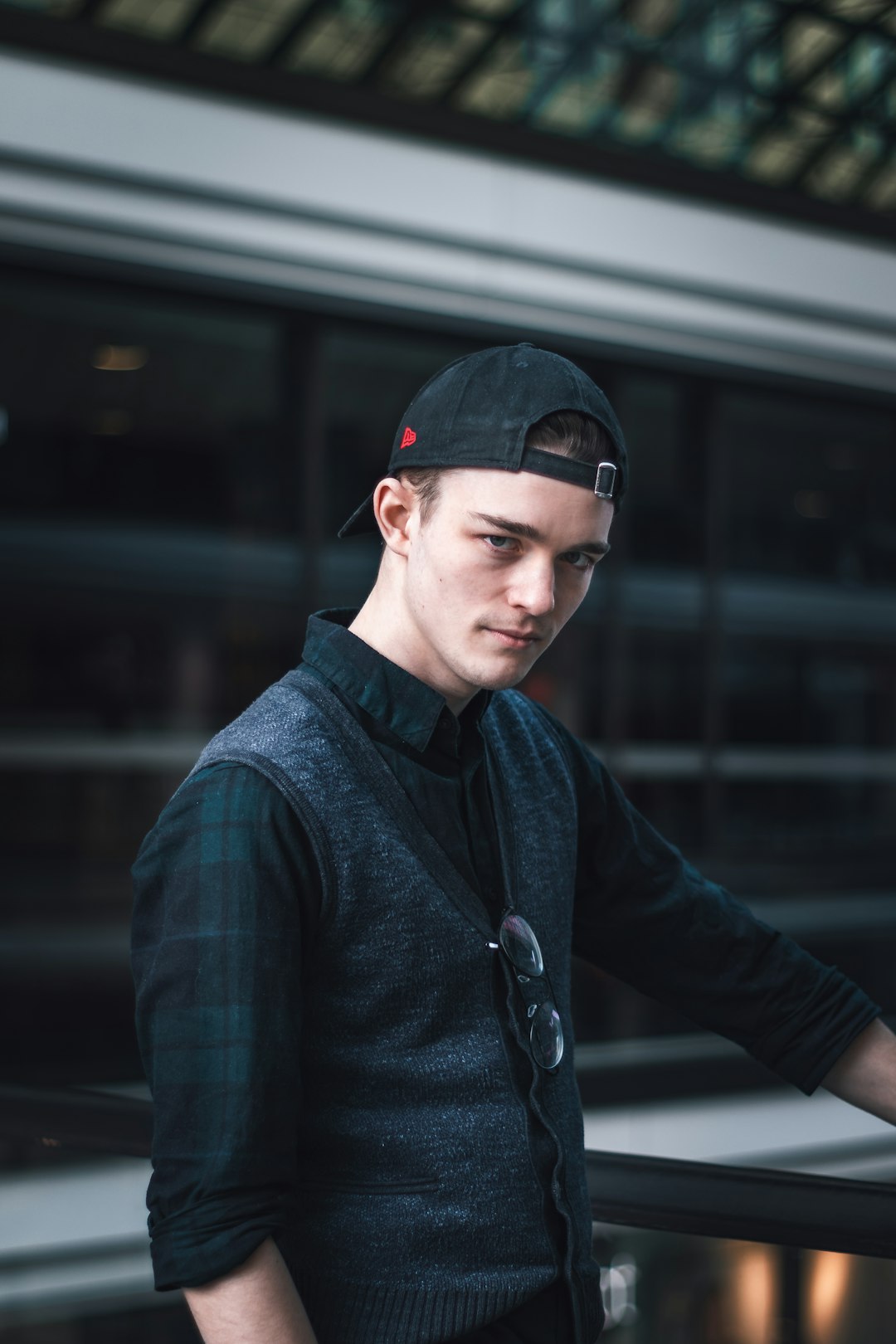 man in blue and black plaid dress shirt wearing black cap