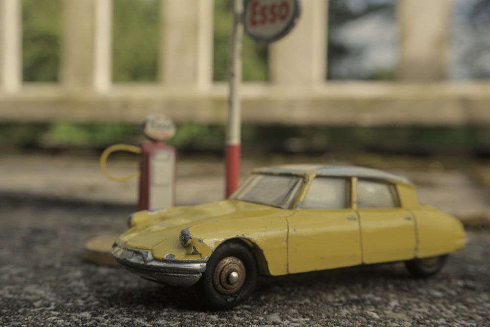 yellow coupe scale model on black and white marble table