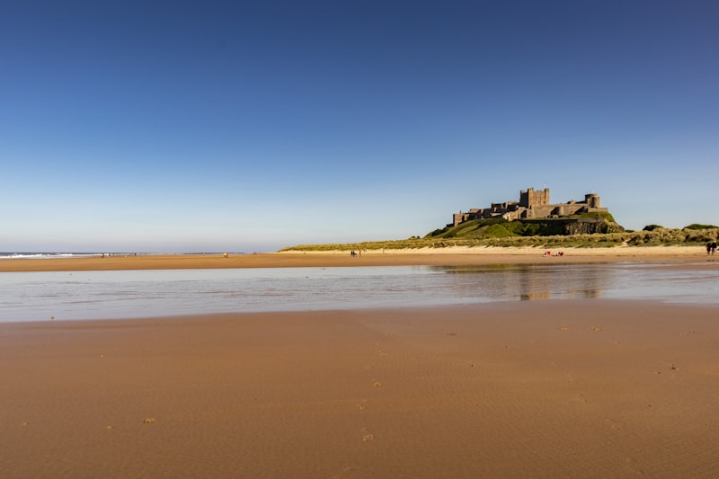 Vast sandy beach beneath Bamburgh Castle