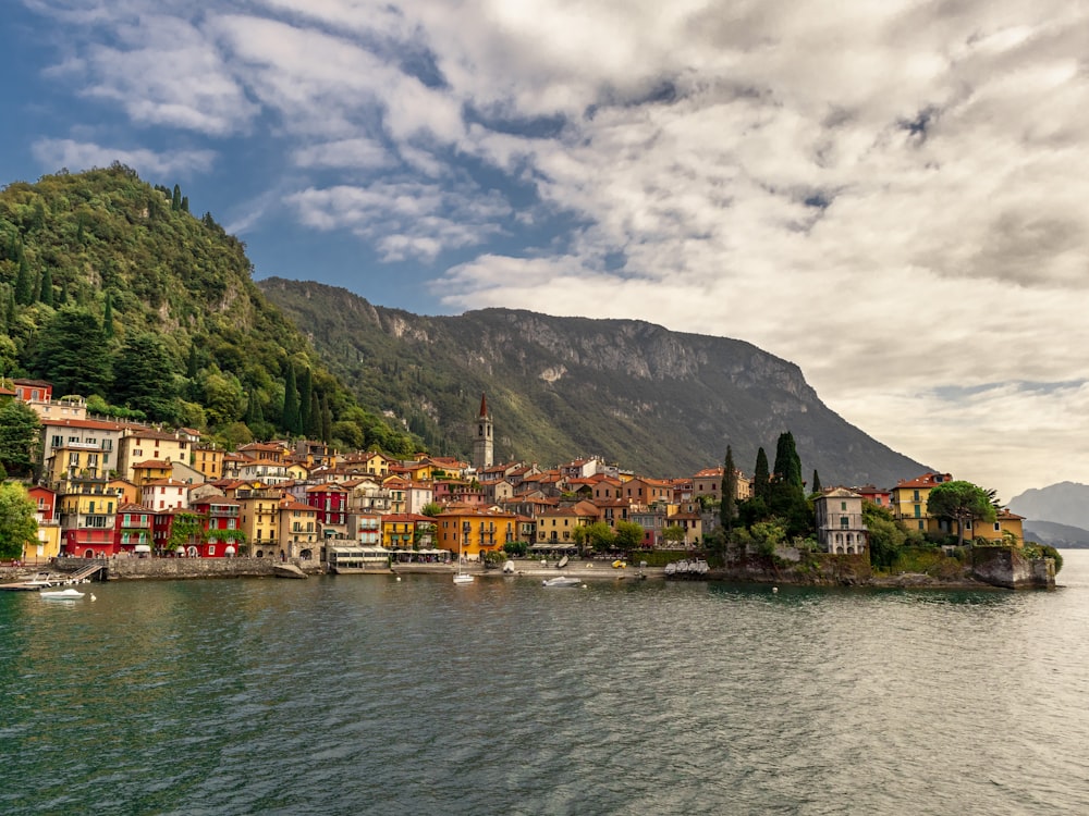 houses near body of water under cloudy sky during daytime