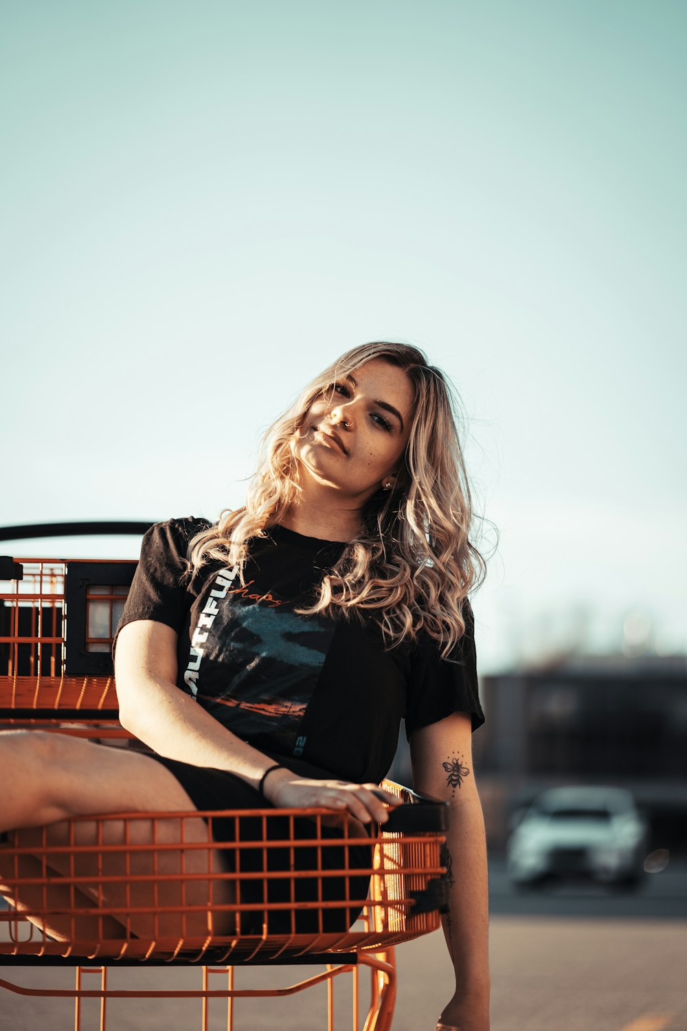 woman in black and white crew neck t-shirt sitting on brown wooden bench during daytime