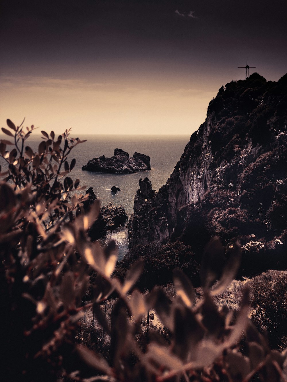 silhouette of mountain beside body of water during sunset