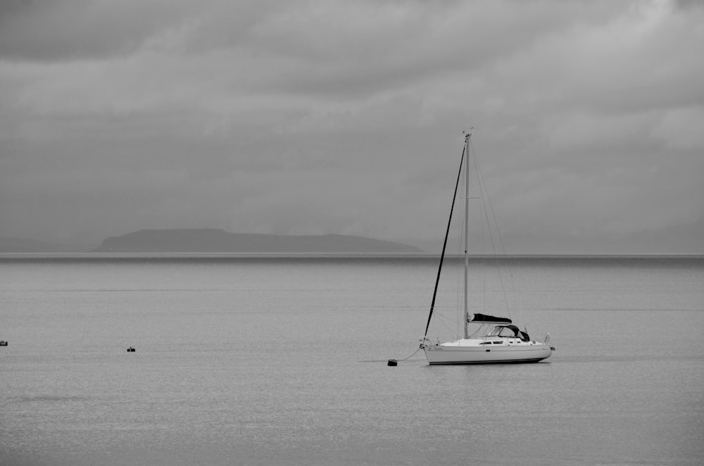 grayscale photo of sailboat on sea