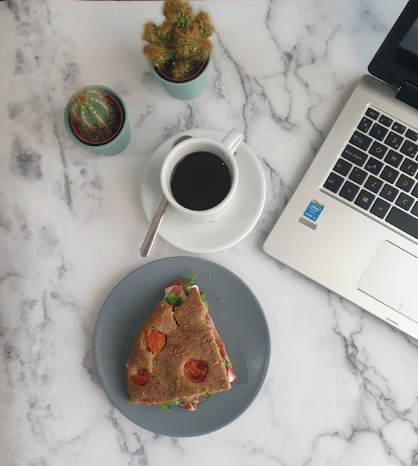 white ceramic mug beside white ceramic plate with food