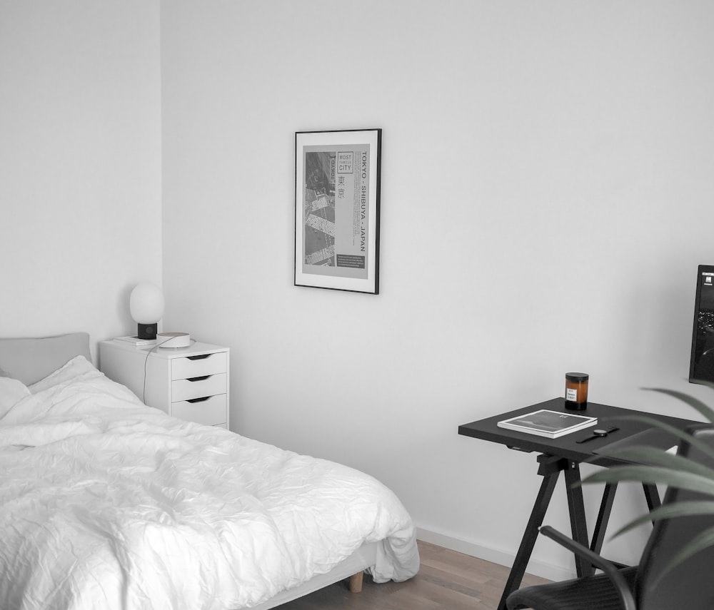 mesa de madeira preta ao lado da cama branca