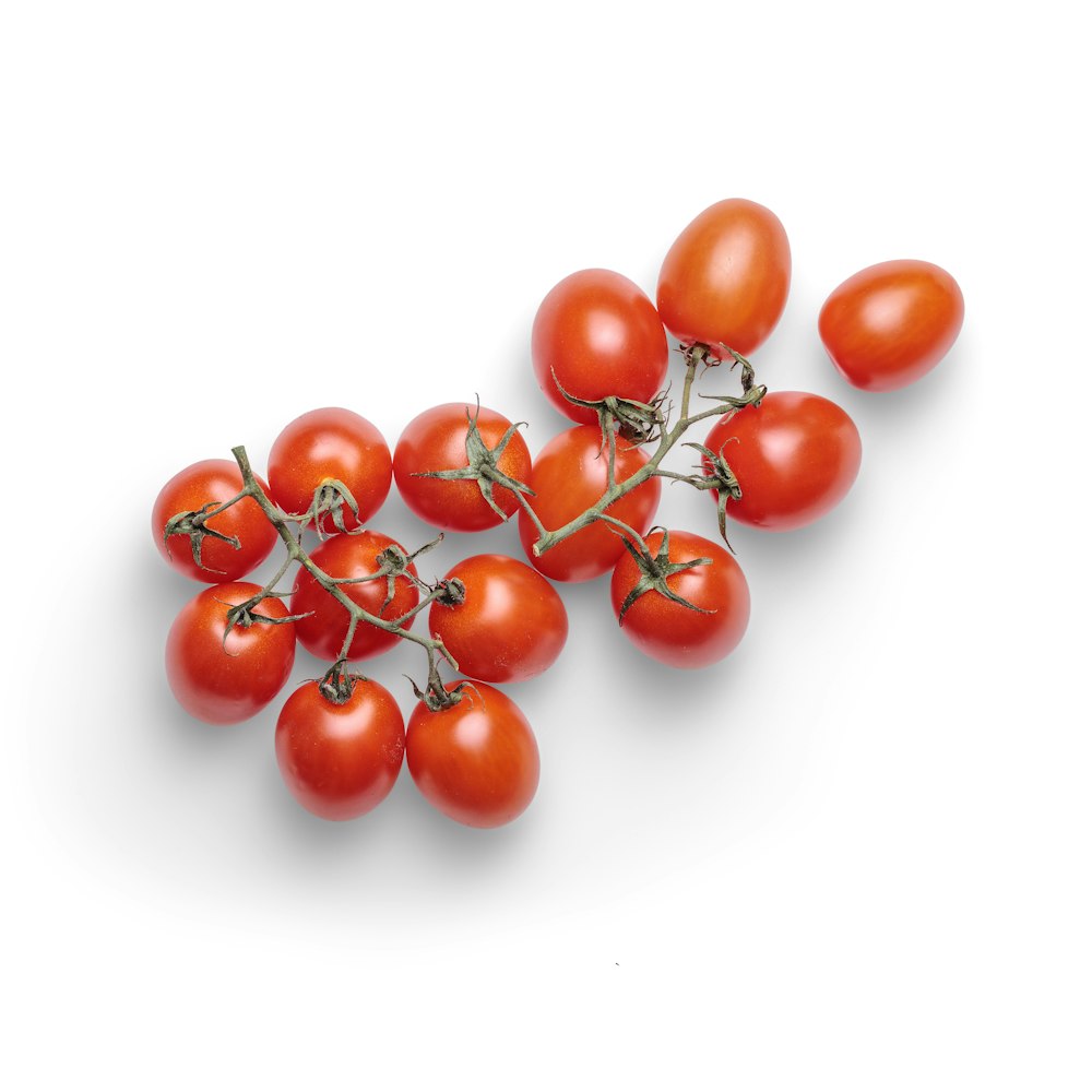tomates cerises rouges sur surface blanche