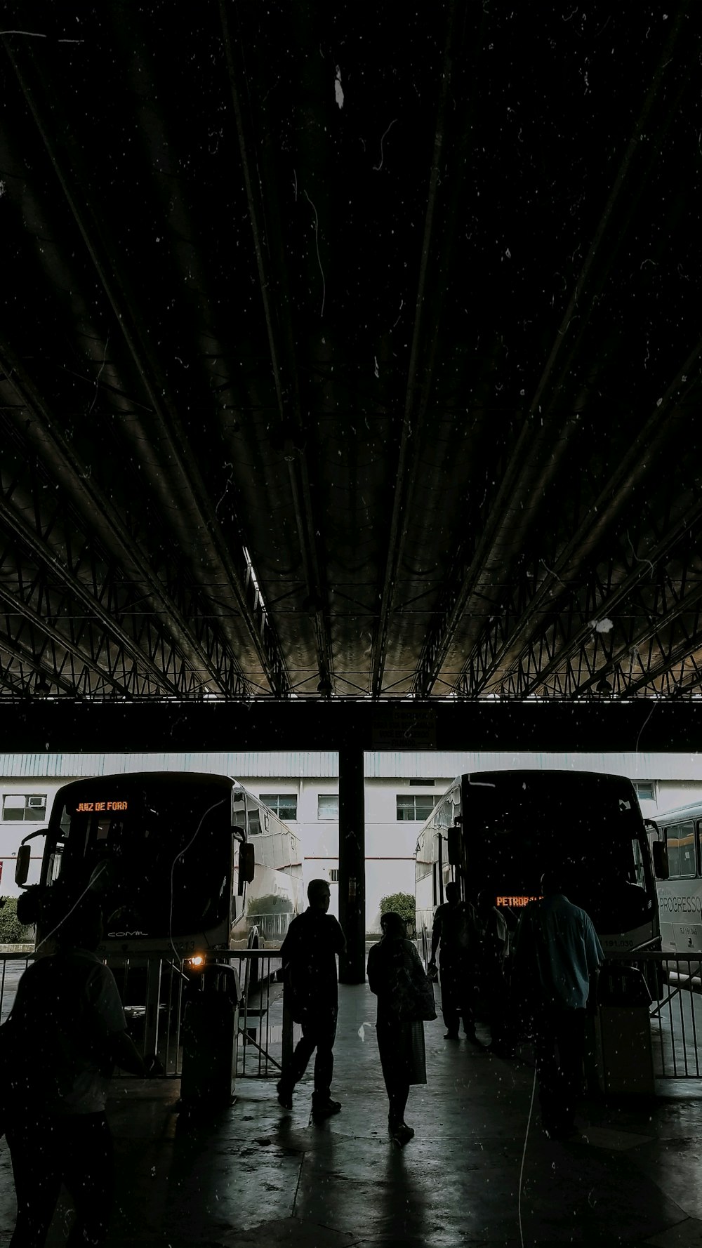 a group of people standing in front of two buses