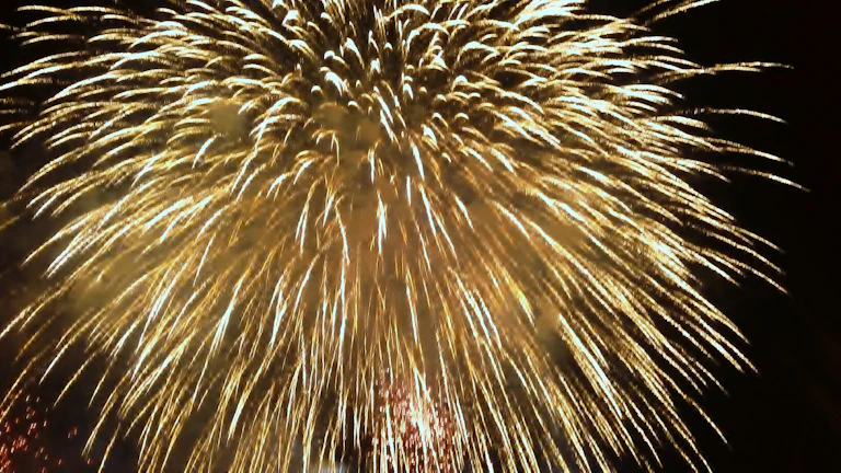 Golden fireworks blooming over a luxurious wedding stage lit with warm lights.