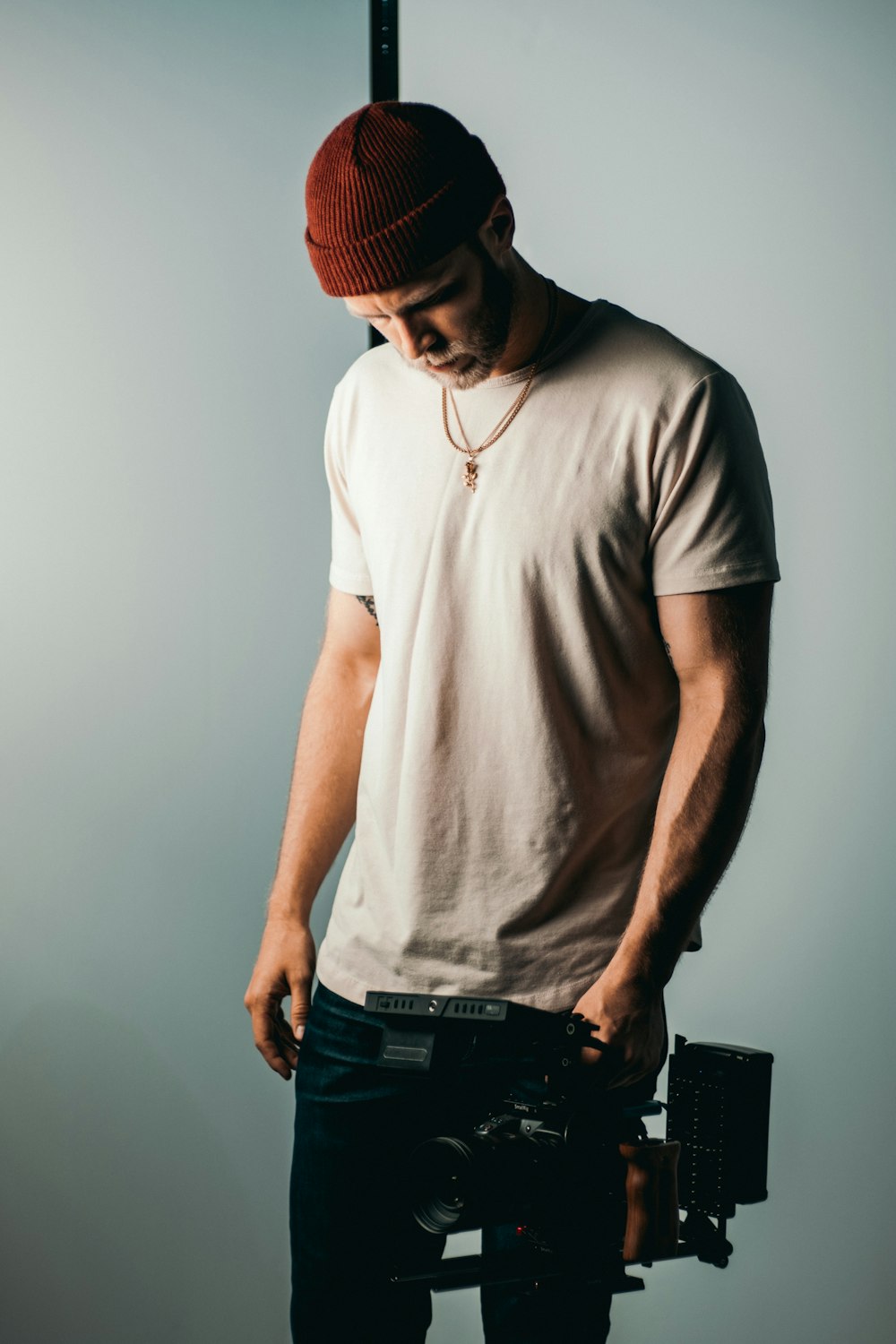 man in white crew neck t-shirt wearing red knit cap