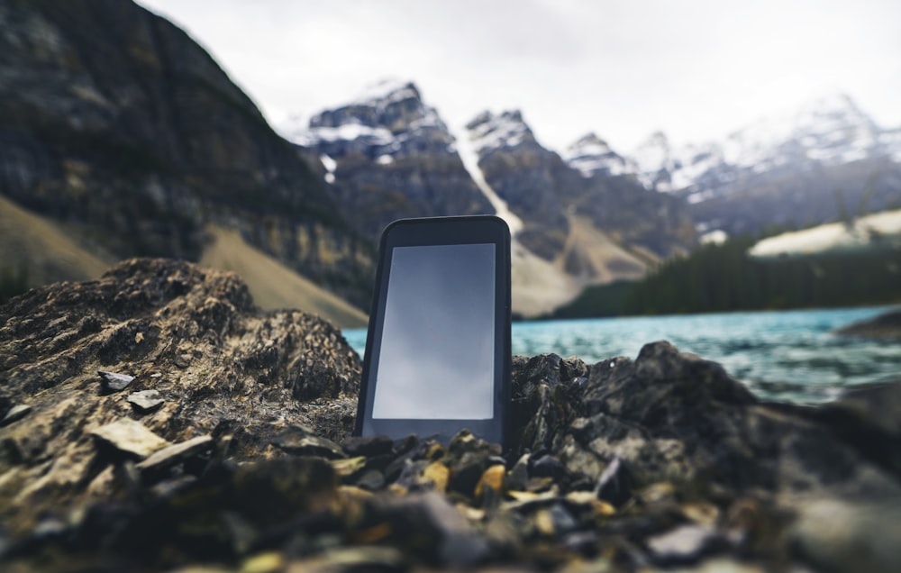 smartphone preto na costa rochosa durante o dia