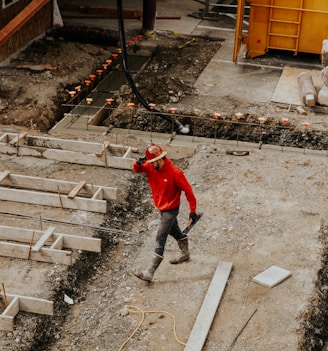 man in red jacket and black pants walking on gray concrete stairs