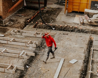 man in red jacket and black pants walking on gray concrete stairs