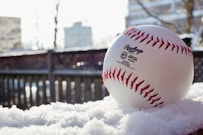 white and red baseball on black metal fence during daytime