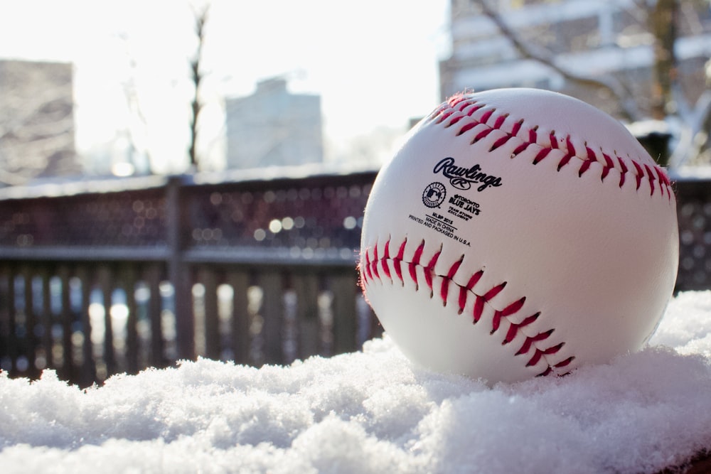 white and red baseball on black metal fence during daytime