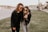 woman in black leather jacket and gray pants standing on green grass field during daytime