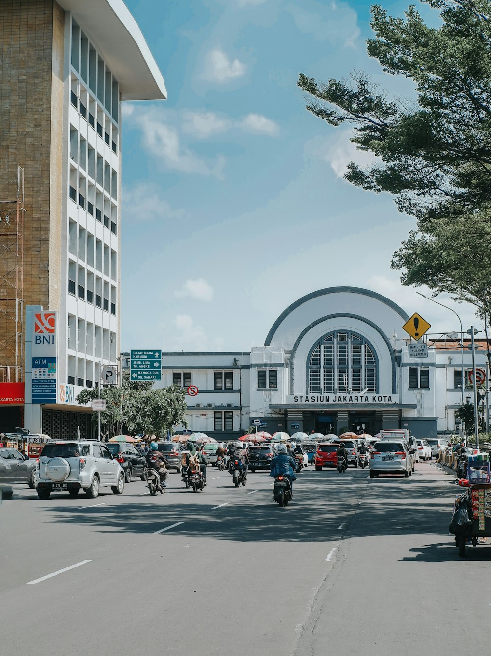 people walking on pedestrian lane near cars and buildings during daytime