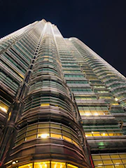 A sleek, modern high-rise tower illuminated against the Mumbai night skyline, showcasing glass facades and golden accents.