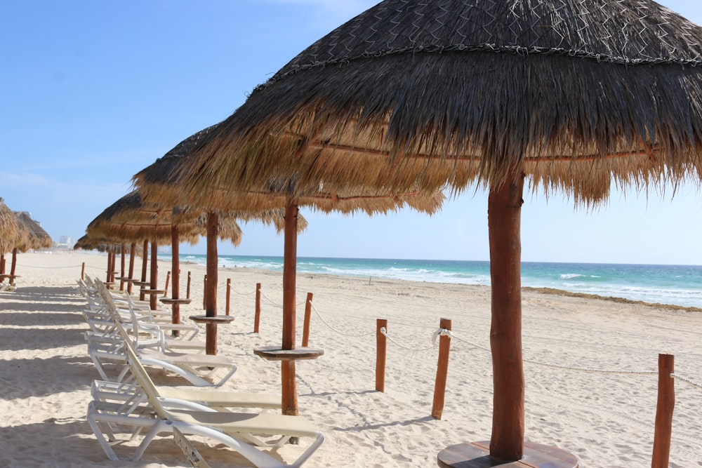 brown wooden beach umbrellas on beach during daytime