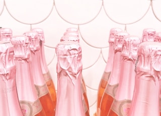 pink glass bottles on brown wooden table