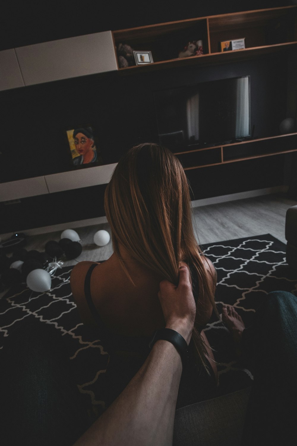 woman in black bracelet sitting on black and white bed