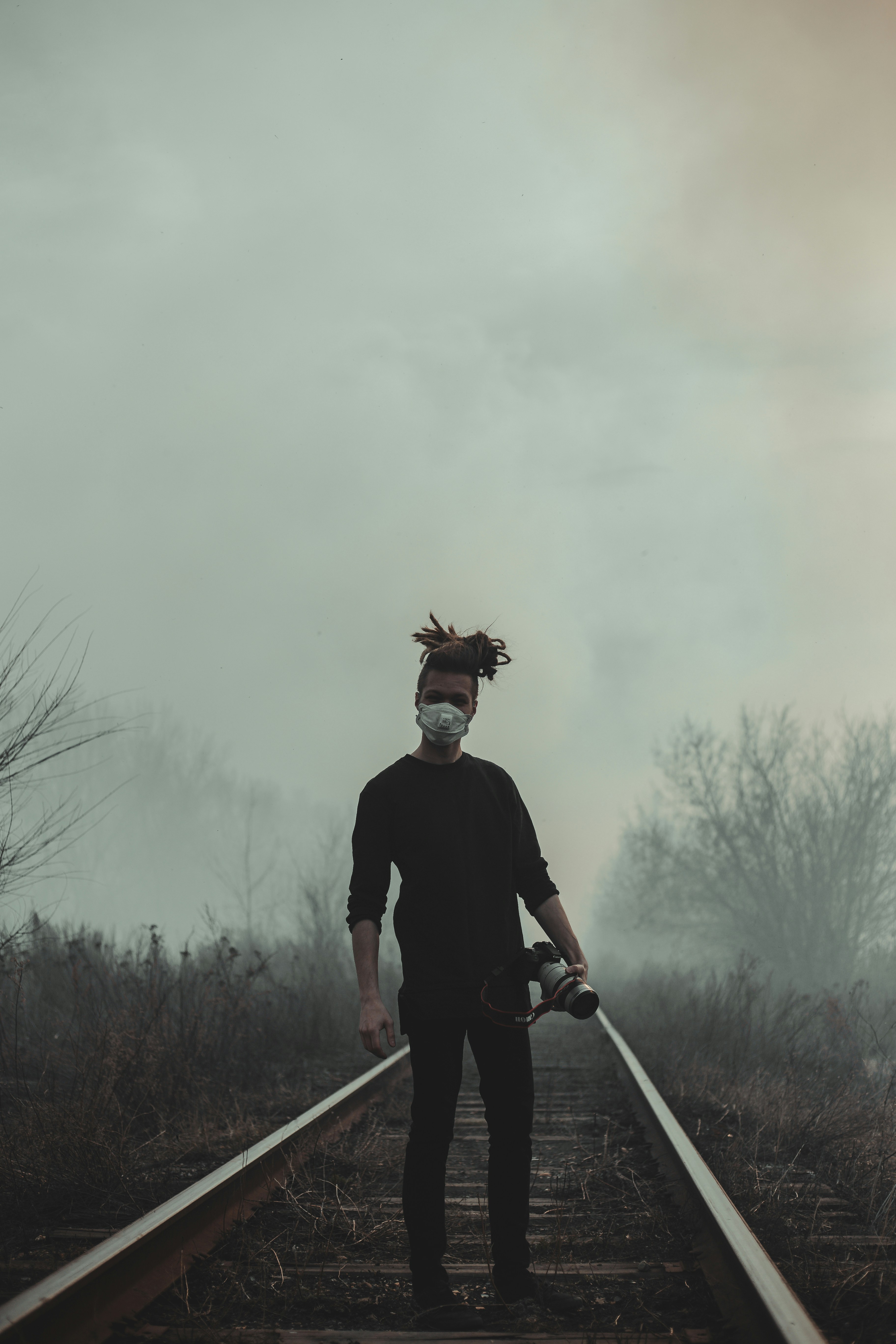 man in black long sleeve shirt and black pants holding white stick