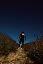 man in black t-shirt standing on green grass field during night time