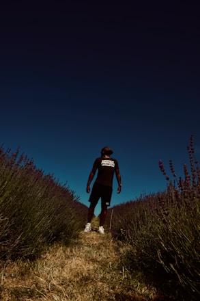 man in black t-shirt standing on green grass field during night time