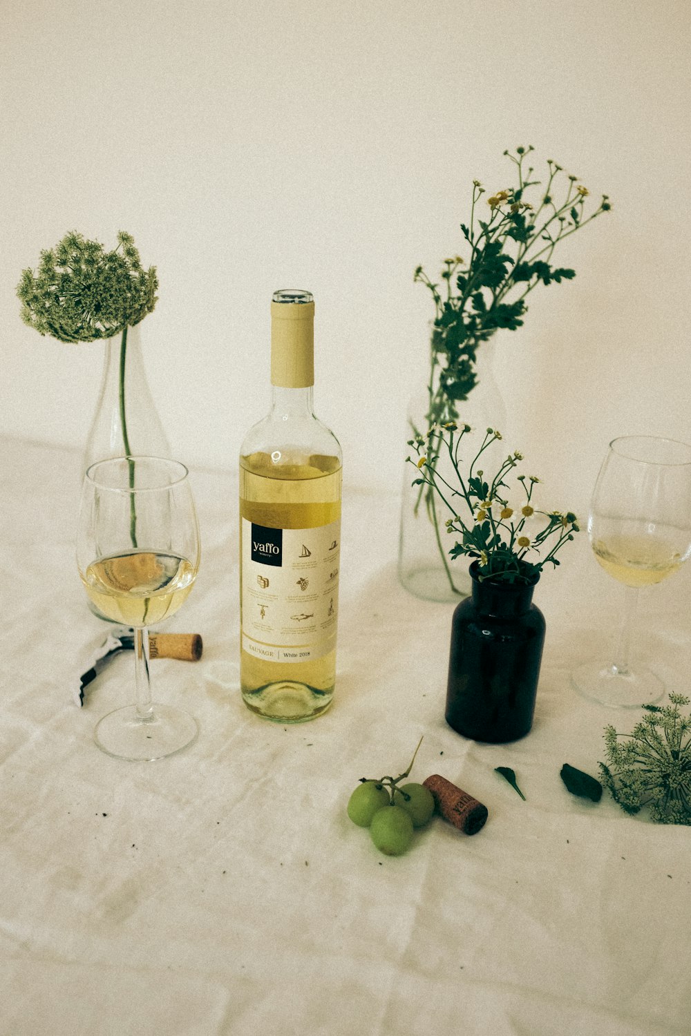 clear wine glass beside white and green bottle