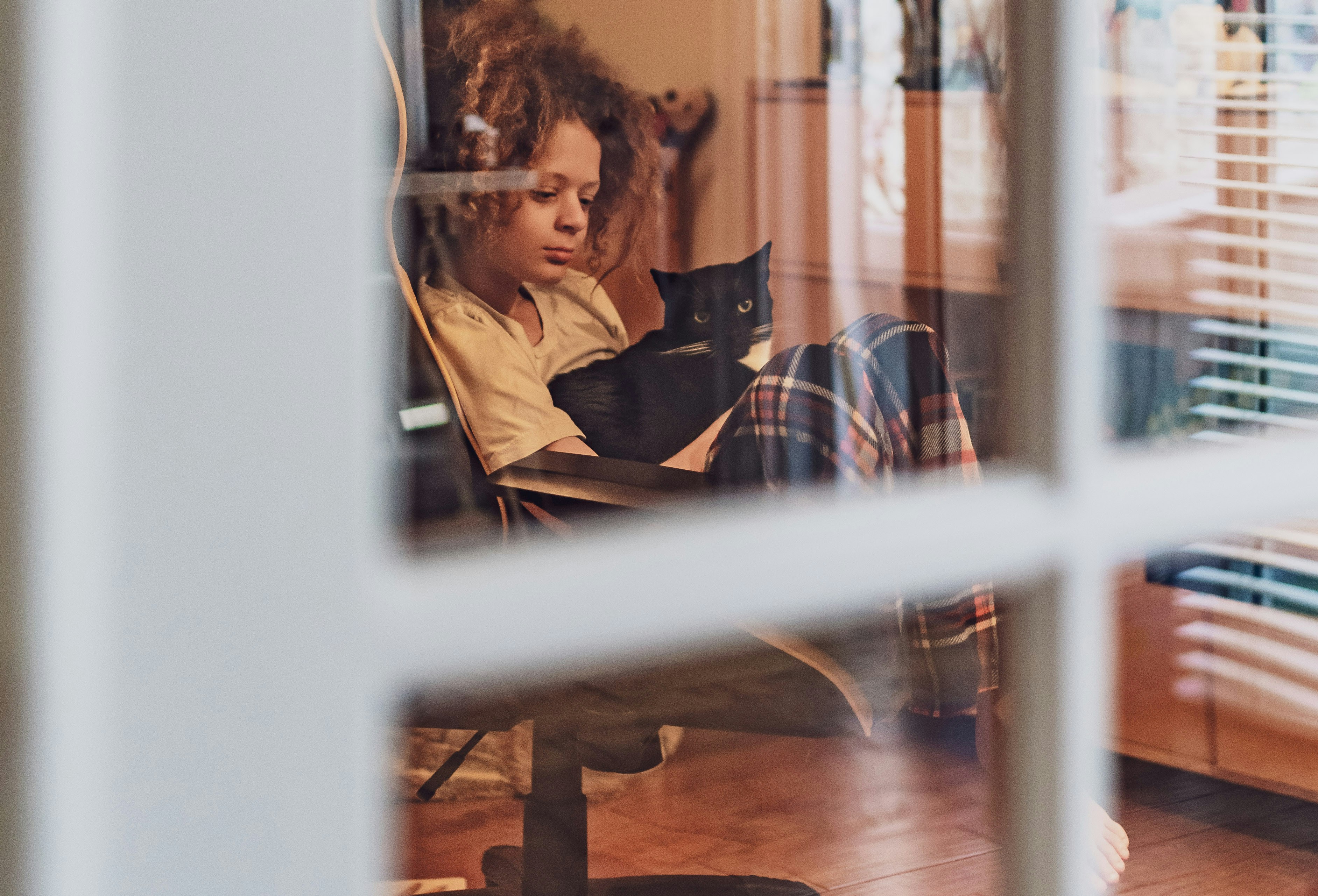 Woman reading behind a window frame