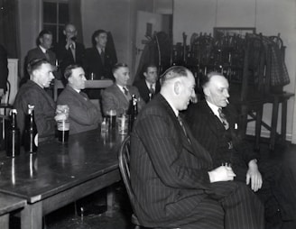 man in black suit sitting on chair