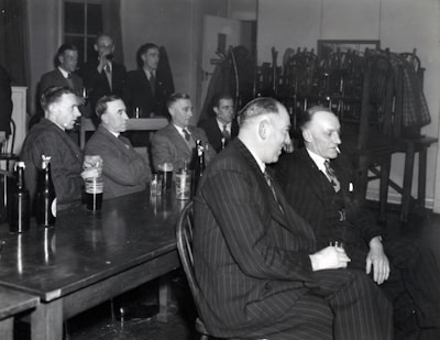 man in black suit sitting on chair