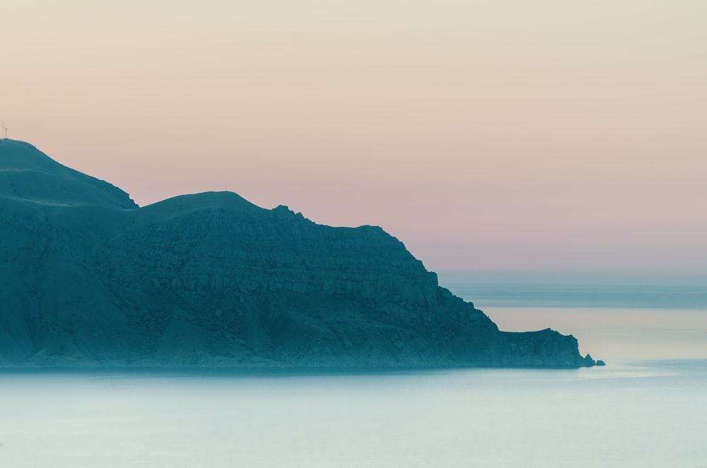 black mountain near body of water during daytime