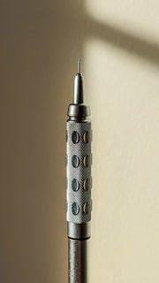 Close-up of a hand holding a sleek, handcrafted wooden pencil with a smooth finish.