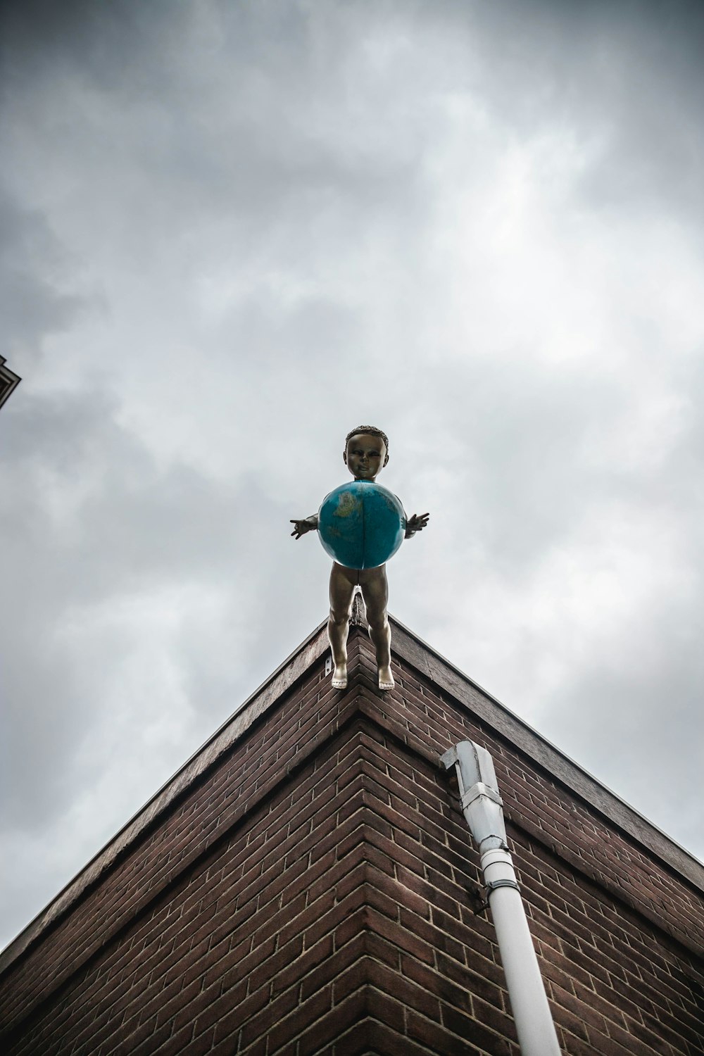 man in blue jacket and blue denim jeans standing on roof top during daytime