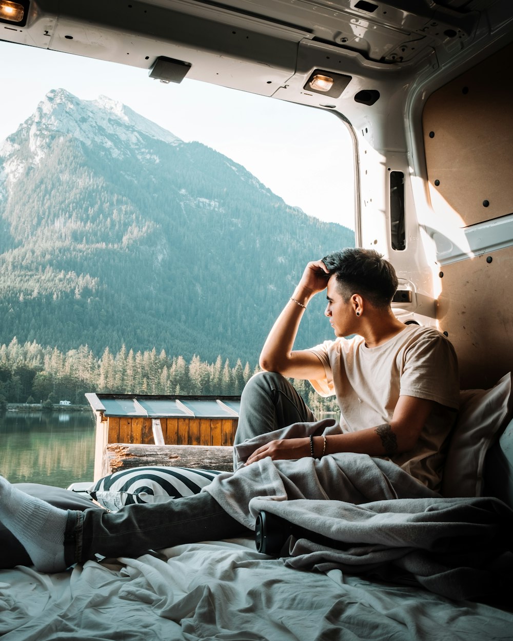 man in gray t-shirt sitting on white van during daytime