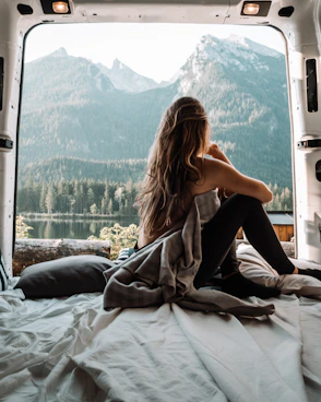 woman in black tank top and black pants sitting on bed