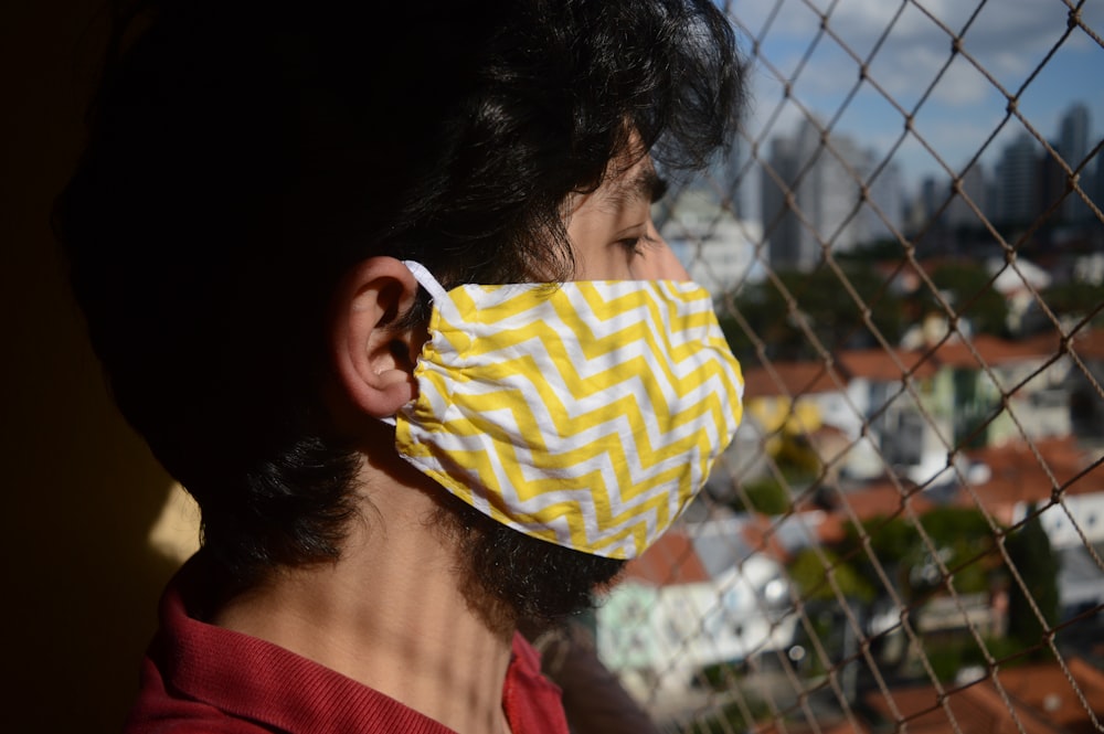 woman in red shirt wearing yellow and white knit cap