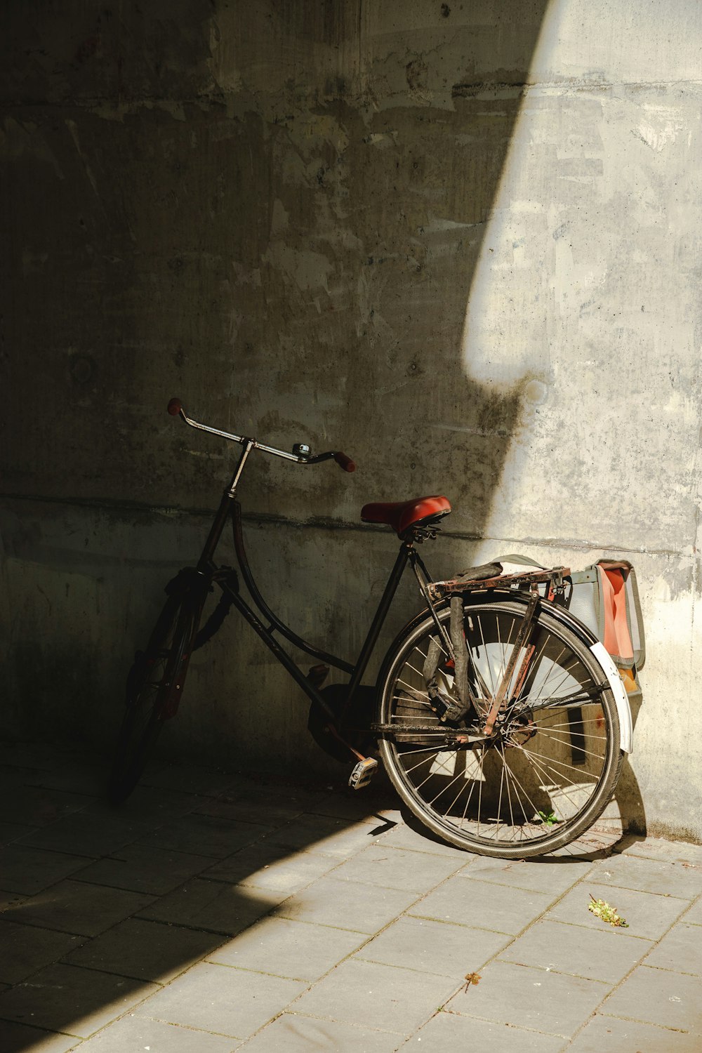 black commuter bike leaning on wall