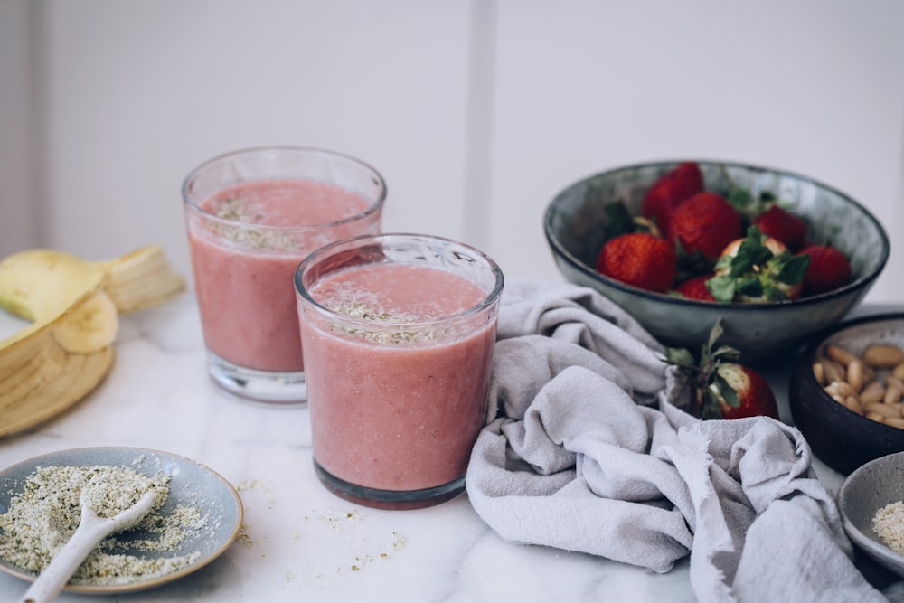 strawberry juice in drinking glass beside silver round coins