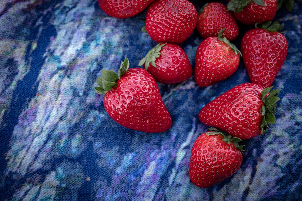 red strawberries on blue textile