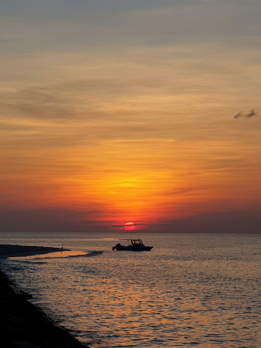 Silhouette des Bootes auf See bei Sonnenuntergang