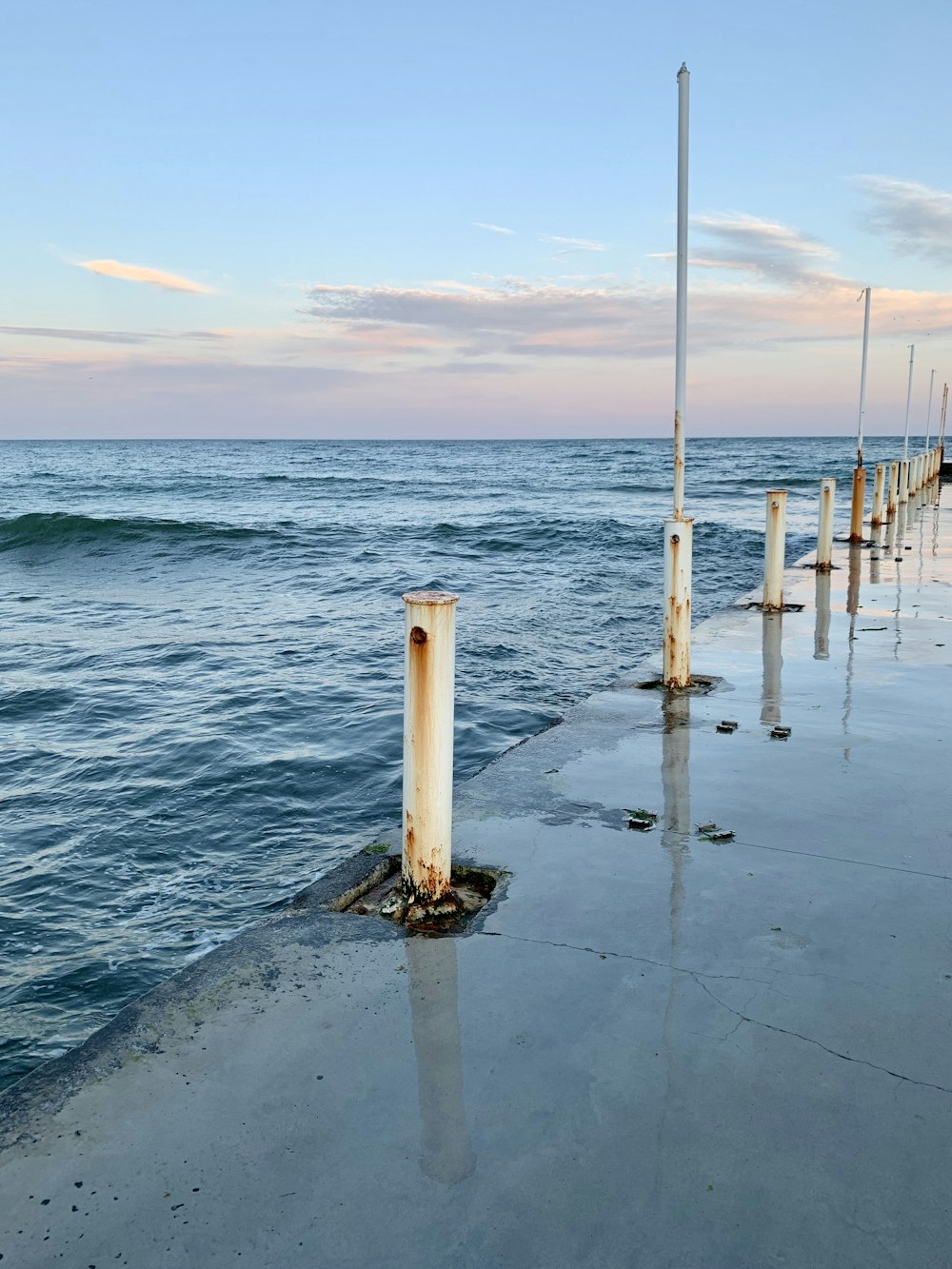 white and brown wooden post on beach during daytime